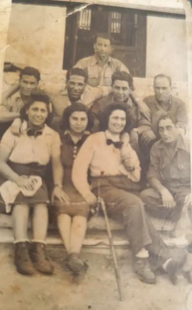 מואיס עומד מאחורי המצולמים באמצע ליד החלון. יושבת משמאל פרדו מרי ולידה איבון רזון